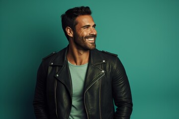 Fototapeta premium Portrait of a blissful man in his 30s sporting a classic leather jacket against a pastel teal background. AI Generation