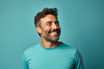 Obraz premium Portrait of a happy man in his 30s sporting a breathable hiking shirt against a pastel teal background. AI Generation