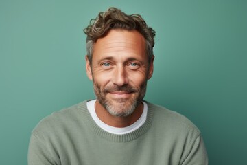 Fototapeta premium Portrait of a merry man in his 40s dressed in a comfy fleece pullover against a pastel teal background. AI Generation