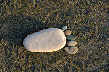 footprint made from stones on the sand