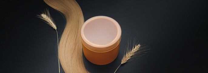 Blond long hair with cream jar and sprigs of ripe wheat. Healthy hair. Hair tools, beauty and...