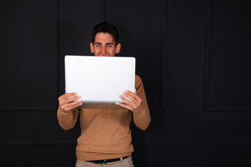 Young attractive student posing with a laptop.
