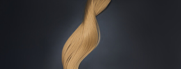 Blond wavy hair on black background. Hairdresser service, hair strength, haircut, hairstyle....