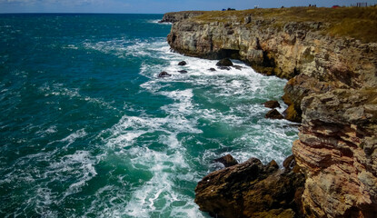 Storm at Black sea. Big waves break on the rocky shore, white foam on the water, Bulgaria