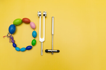 Orchidometer, Neurological Hammer and Tuning Fork C 128 on Yellow Background with Space for Text