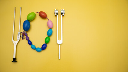 Orchidometer, Neurological Hammer and Tuning Fork C 128 on Yellow Background with Space for Text