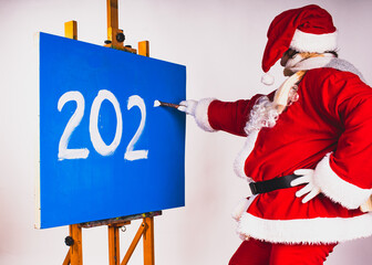 Santa Claus writes the numbers 2024 on the blue background.
