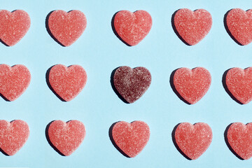 Pattern of gummy vitamin candy in shape of heart on blue background .Concept photography. High quality photo