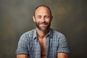 Fototapeta premium Portrait of a blissful man in his 40s wearing a comfy flannel shirt against a minimalist or empty room background. AI Generation