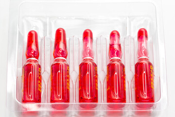 Injection ampoules of hormone B12 in selective focus. Ampoules containing solution for injection used for supplementation of vitamin B12 contain Cyanocobalamin.