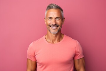 Obraz premium Portrait of a smiling man in his 40s donning a trendy cropped top against a solid color backdrop. AI Generation