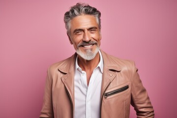 Obraz premium Portrait of a grinning man in his 50s sporting a stylish leather blazer against a solid pastel color wall. AI Generation