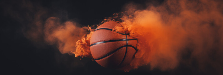 orange smoke reveals a basketball on a black background 