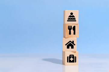 Wooden cube with food Clothing, housing, medicine, four basic human needs concept on a blue background and  copy space.