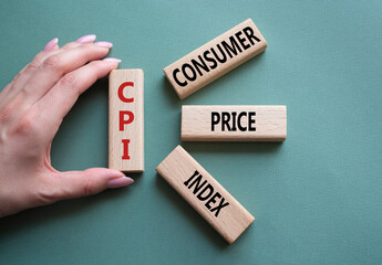 CPI - Consumer Price Index symbol. Concept word CPI on wooden blocks. Businessman hand. Beautiful grey green background. Business and CPI concept. Copy space. - obrazy, fototapety, plakaty