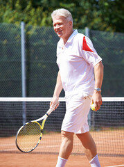 Tennis, sports and senior man on court for playing game, match and practice for competition. Retirement, happy and elderly person with racket and ball for training, exercise and workout for hobby