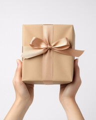 person holding a wrapped gift box with a bow on a white background 