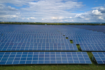 Aerial view of big sustainable electric power plant with many rows of solar photovoltaic panels for producing clean electrical energy. Renewable electricity with zero emission concept