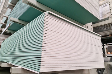 Gypsum plasterboard stacked in stacks at a hardware store.