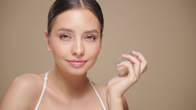 Portrait young woman uses creams of her face. Concept for fresh moisturized skin beautiful closeup cosmetic face happy healthy model.   Model with a jar of face cream