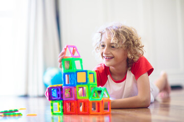 Child playing with magnetic building blocks.