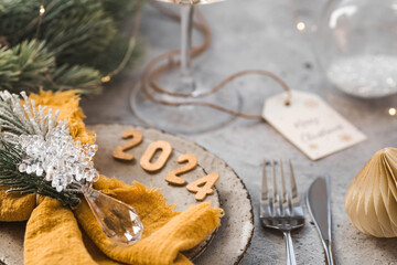 Table setting. Stylish plates, napkin, glass, champagne, Christmas tree branches and Christmas...