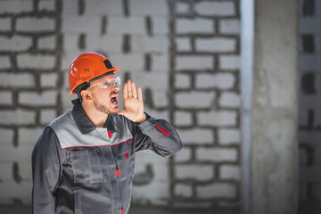 Portrait of a construction worker who shouts to other workers because of poor radio communication at a construction site.