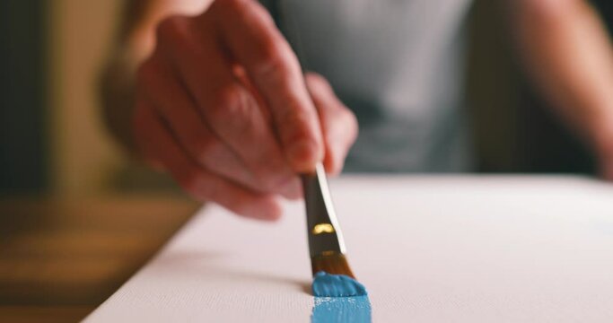Artist making a brushstroke on a canvas painting 
