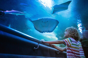 Family in aquarium. Kids watch fish, marine life