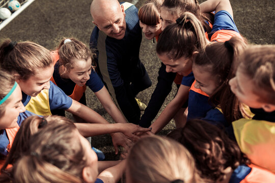 Coach Strategizing with Youth Soccer Players on the Field