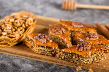 Pieces of baked baklava in honey on a wooden board