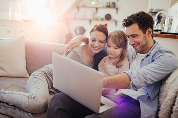 Fototapeta premium Family spending time together with laptop in living room