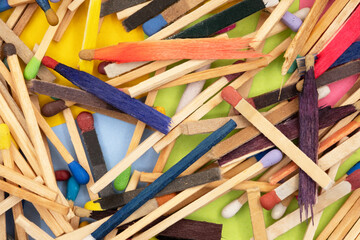 matchsticks of various shapes and colors with multicolored paper sticky notes on background