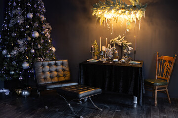 New Year's dark interior, Christmas tree with New Year's decorations and a decorated table in a dark style