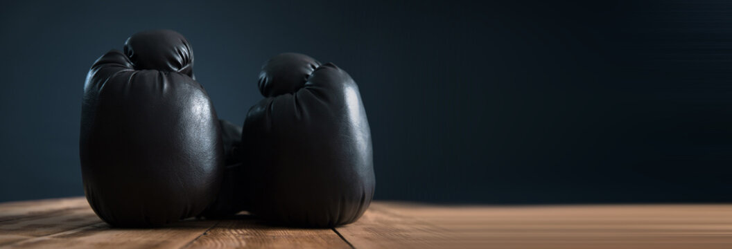 Black boxing gloves on wooden table