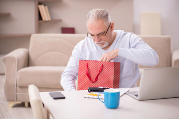 Old man with many bags in Christmas concept at home