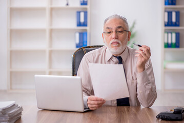 Old male employee working in the office