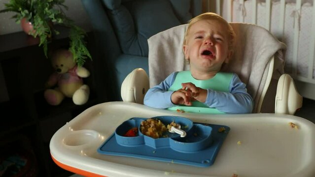 The child cries and fusses while eating