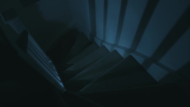 Light illuminating old staircase inside a house at night