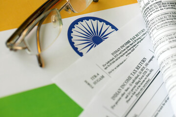 Indian income tax return blank form with pen and indian rupees bills on indian country flag close...