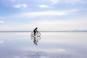 person riding a bike on reflection of sky