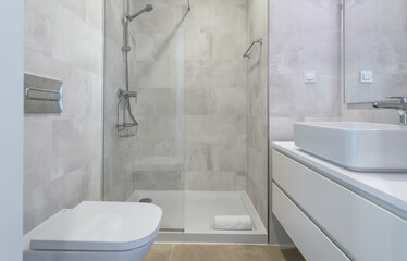 Modern bathroom design with bath and shower cubicle and wash hand basin. towel on the floor