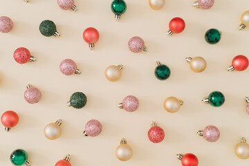 Creative colorful Christmas baubles decoration pattern on pastel cream background. Minimal...