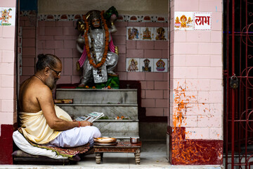 pandit sitting in front of hanuman ji and chanting 