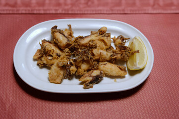 dish with fried squid with lemon slice