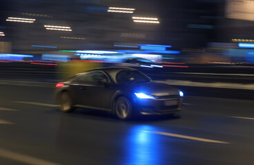 Sports car driving at night on the highway