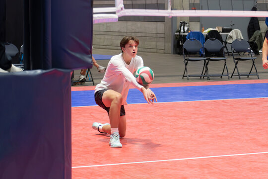 Indoor volleyball player passing the ball with knee on the ground