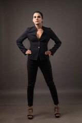 a business woman standing in black suit giving bold look depicting luxury and fashion on black...