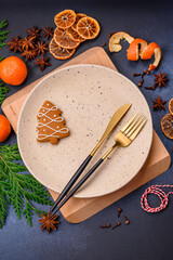 Beautiful festive Christmas composition of an empty plate, tangerine and gingerbreads