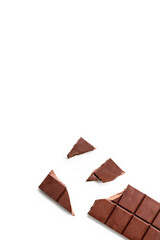 Broken organic milk chocolate bar isolated on a white background from above, top view